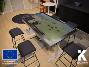 Pöydäksi muutettu kosketusnäyttö, jossa näkyy simuloitu tilannekuva 3d-malleilla