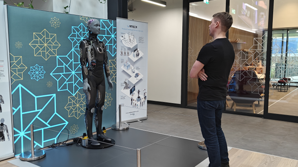 Mieshenkilö seisoo ihmisrobotin edessä