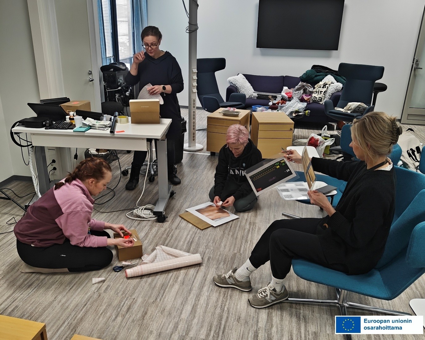 Opettajat askartelemassa pakopelin materiaaleja