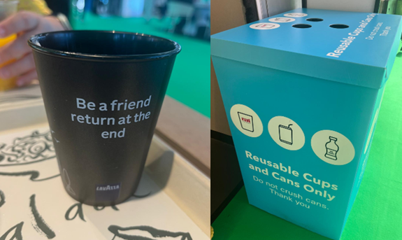 Kaksiosainen kuva. Vasemmalla muovikuppi pöydällä. Kupissa lukee "Be a friend return at the end". Oikealla puolella pahvinen laatikko lattialla. Laatikon yläosassa on kolme reikää. Sen kyljessä kolme ympyräkuvaketta joissa mukin, tölkin ja muovipullon kuvat. Kuvien alla lukee "Reusable Cups and Cans Only. Do not crush cans. Thank you."